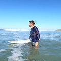Surfeur de profil dans l'eau en top lycra waves bleu