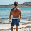 Homme de dos devant la plage en boardshort Saint Jacques logo semi elastique